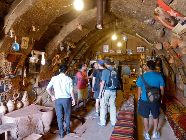 Inside a cave pottery workshop Travellers browsing pottery and ceramics beneath the stone vaults of a cave workshop.