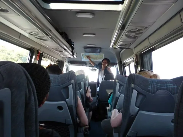 Travellers seated inside a tour vehicle during their journey.