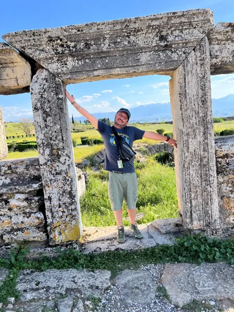 A guest posing in a stone doorway during a heritage visit.