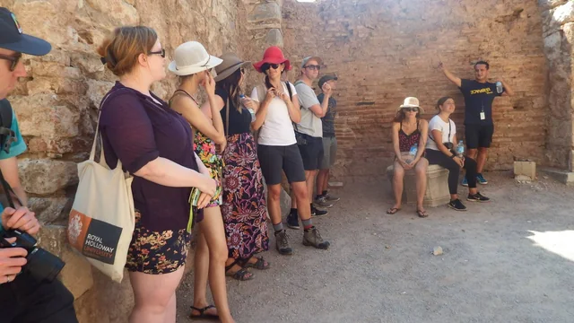 Travellers gathered inside a historic stone-walled space during a guided visit.