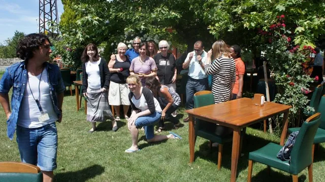 Travellers gathered in a garden beside outdoor tables during their trip.