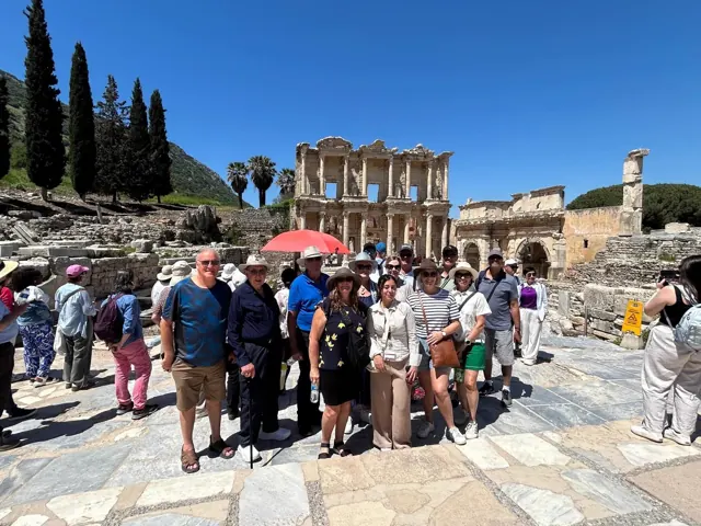 Travellers gathered among the ancient ruins at Ephesus.