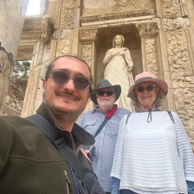 Guests and their guide beside an ancient statue at Ephesus.