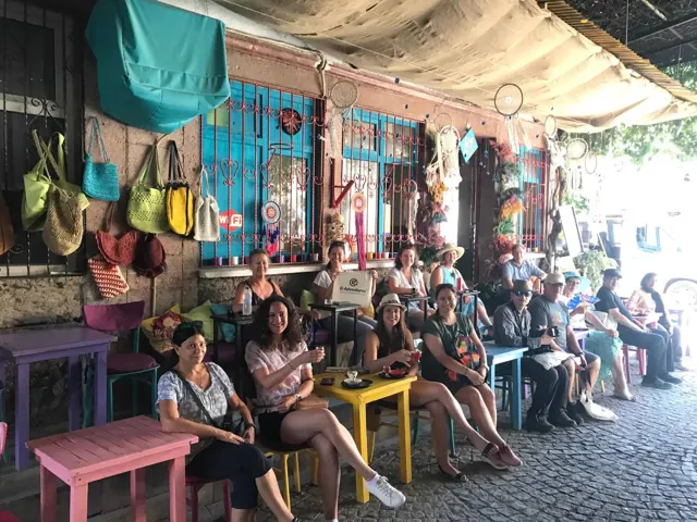 A tour group enjoying a colourful village café terrace.