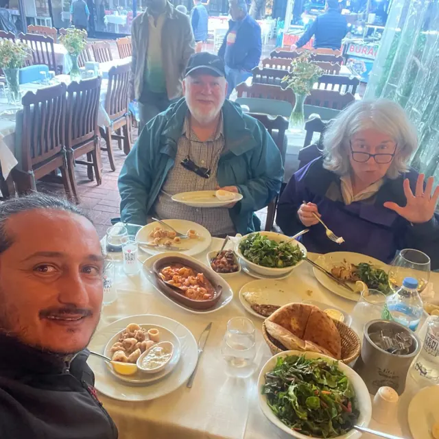 Travellers sharing local dishes around a restaurant table.